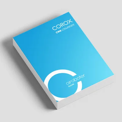 Eine Broschüre mit leuchtend blauem Umschlag, auf dem oben der weiße Schriftzug COROX CRM LÖSUNGEN und unten airoboter inside zu lesen ist, zeigt modernes Corporate und Grafik Design, platziert auf einer schlichten hellgrauen Fläche.