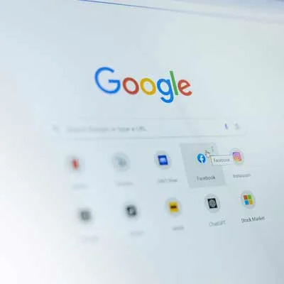 Es geht um SEO und AEO Optimierung. Ein Computerbildschirm, der die Google-Startseite mit der Suchleiste und mehreren Website-Verknüpfungen, darunter Facebook, Instagram und andere, unterhalb der Suchleiste anzeigt.