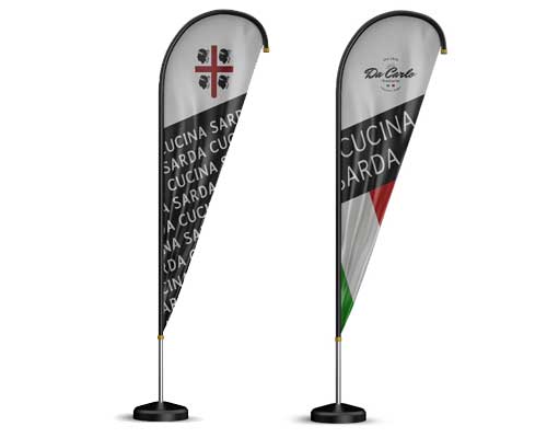 Zwei vertikale, tropfenförmige Beachflags sind auf Ständern ausgestellt: Eine zeigt die sardische Flagge und den Schriftzug "Cucina Sarda", während auf dem anderen Aufsteller "Da Carlo Cucina Sarda" mit einem rot-weiß-grünen, italienisch inspirierten Streifen zu lesen ist.