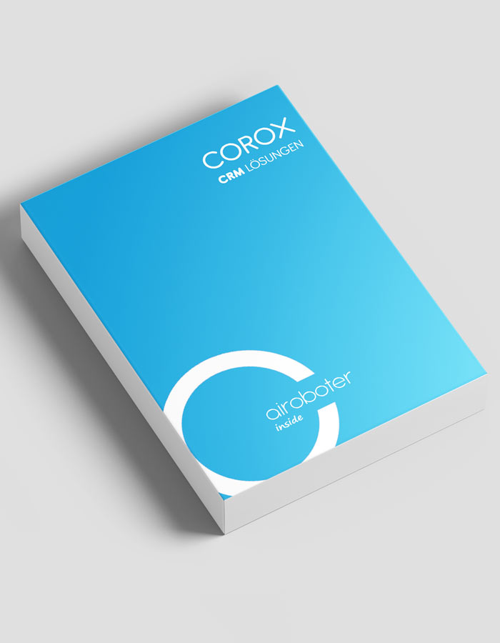 Eine blaue Broschüre oder ein Booklet mit dem Titel COROX CRM Lösungen mit weißem Text und kreisförmigen grafischen Elementen zeigt das Corporate Design von Druck auf einem hellgrauen Hintergrund in einer schrägen Ansicht.
